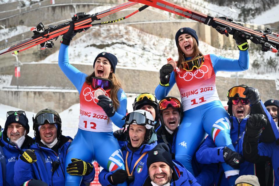 Silver medallist Italy's Sofia Goggia (L) and bronze medallist Italy's Nadia Delago (R) celebrate with their team during the women's downhill victory ceremony of the Beijing 2022 Winter Olympic Games at the Yanqing National Alpine Skiing Centre in Yanqing on February 15, 2022. (Photo by Jeff PACHOUD / AFP) (Photo by JEFF PACHOUD/AFP via Getty Images)