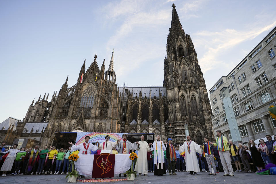 A public blessing ceremony with hundreds of believers takes place in front of the Cologne Cathedral in Cologne, Germany, Wednesday, Sept. 20, 2023. Several Catholic priests held a ceremony blessing same-sex and also re-married couples outside Cologne Cathedral in a protest against the city's conservative archbishop, Cardinal Rainer Maria Woelki. (AP Photo/Martin Meissner)