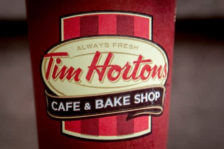 A Tim Hortons coffee cup is seen on the ground outside a shop near Times Square in New York August 26, 2014. REUTERS/Brendan McDermid