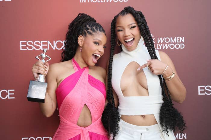 Halle and Chloe Bailey smiling, with Halle holding an award, and both in stylish attire at an Essence event