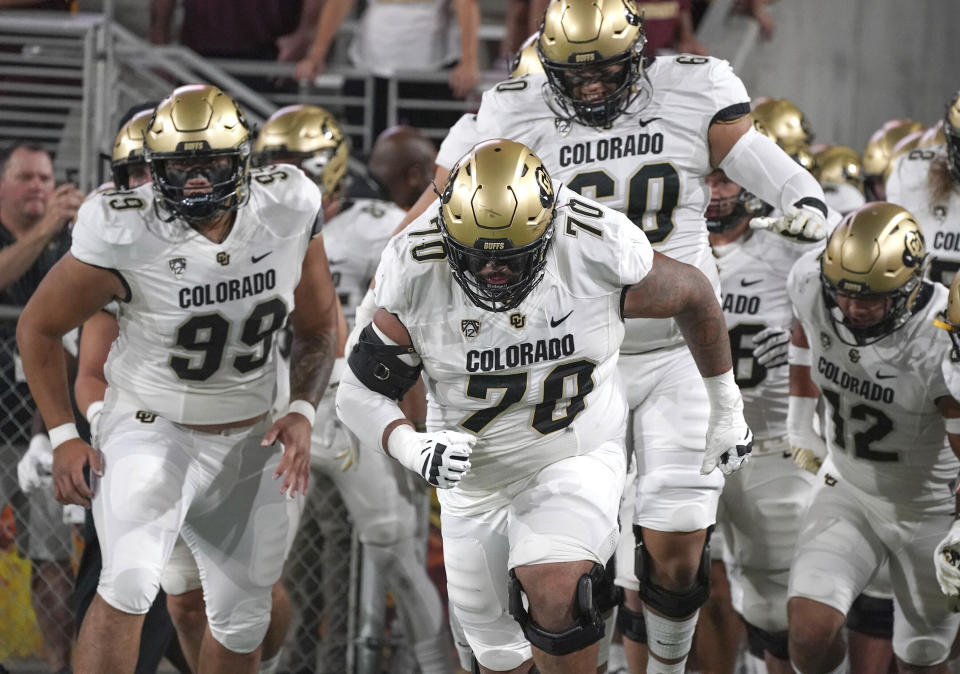 FILE - Colorado players lead by Casey Roddick (70) charge out onto the field before their NCAA college football game with Arizona State, Sept 25, 2021, in Tempe, Ariz. Colorado offensive lineman Casey Roddick nearly had his football career ended after a case of COVID-19 developed into a serious bout with myocarditis, an inflammation of the heart wall. These days, the left guard from California doesn't take even one snap for granted. That's why he relished his new role as team captain. (AP Photo/Darryl Webb, File)