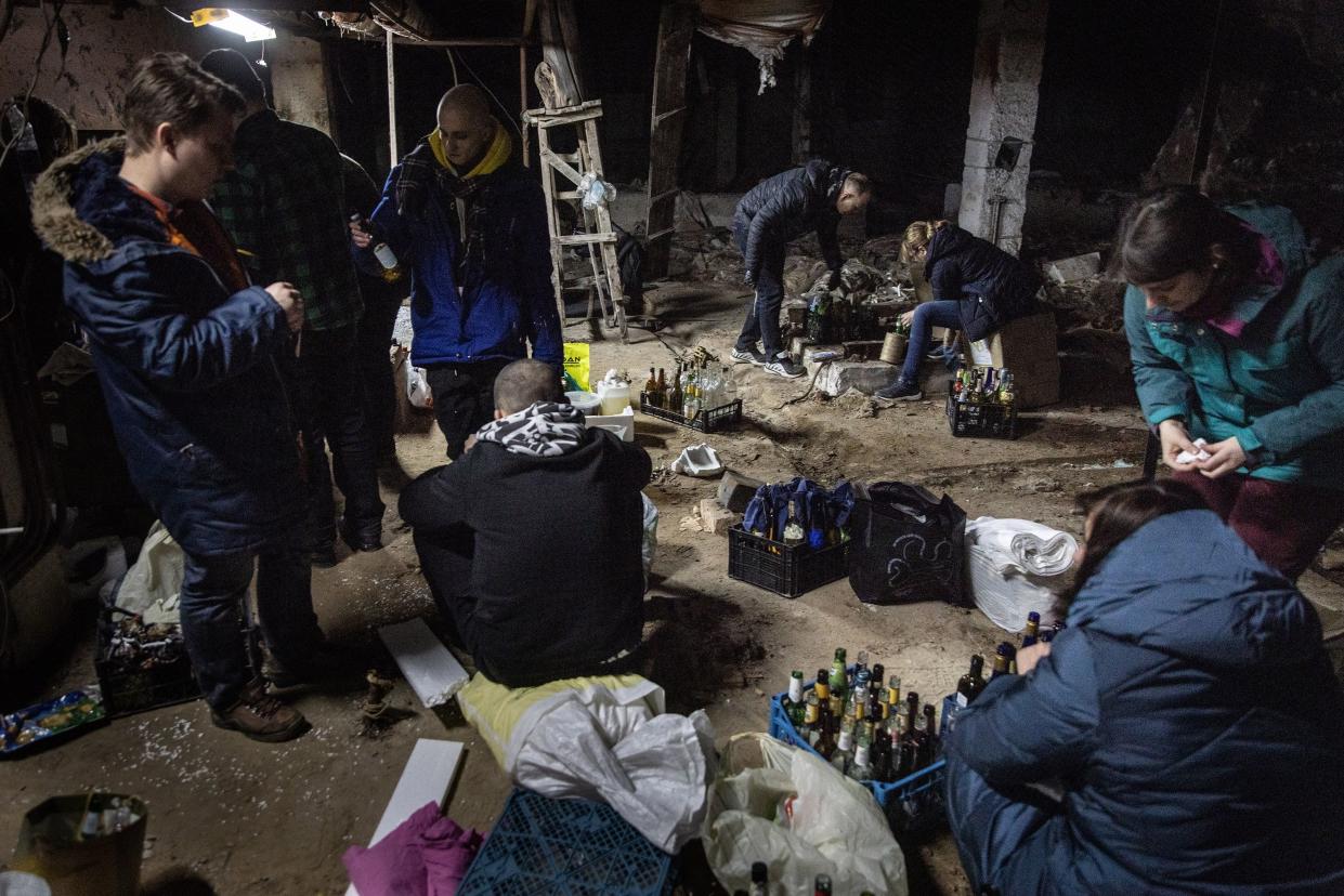 Volunteers work to make molotov cocktails in the basement of a bomb shelter on Feb. 26, 2022, in Kyiv, Ukraine.