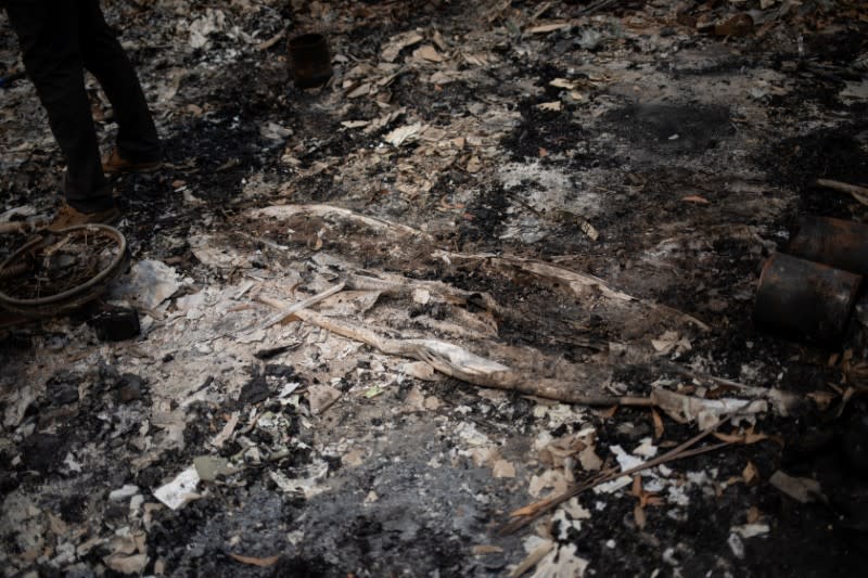 Australian surfer David Ford, 62, stands next to the remains of a surfboard, part of his vintage surfboard collection that was destroyed in the recent bushfires in Lake Conjola