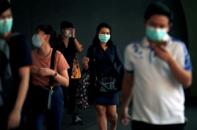 FILE PHOTO: People wear masks as a preventive measure against the coronavirus outbreak, in Bangkok