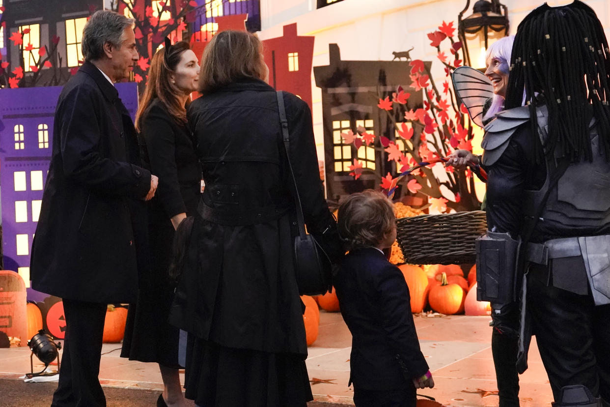 Secretary of State Antony Blinken and members of his family talk with first lady Jill Biden as she and President Joe Biden give treats to trick-or-treaters on the South Lawn of the White House, Monday, Oct. 31, 2022, in Washington. (AP Photo/Alex Brandon)