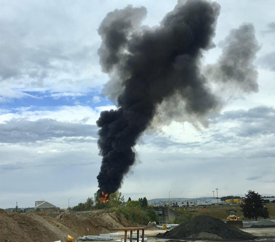 In this photo provided by Antonio Arreguin, smoke fills the sky after a World War II-era bomber plane crashed, Wednesday, Oct. 2, 2019 outside Bradley International Airport north of Hartford, Conn. A spokesman for Gov. Ned Lamont confirmed the crash of the B-17 plane. (Antonio Arreguin via AP)