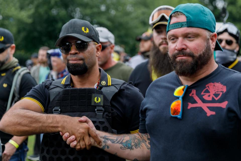 Proud Boys leader Enrique Tarrio, left, and organizer Joe Biggs congratulate each other after a rally in Portland.