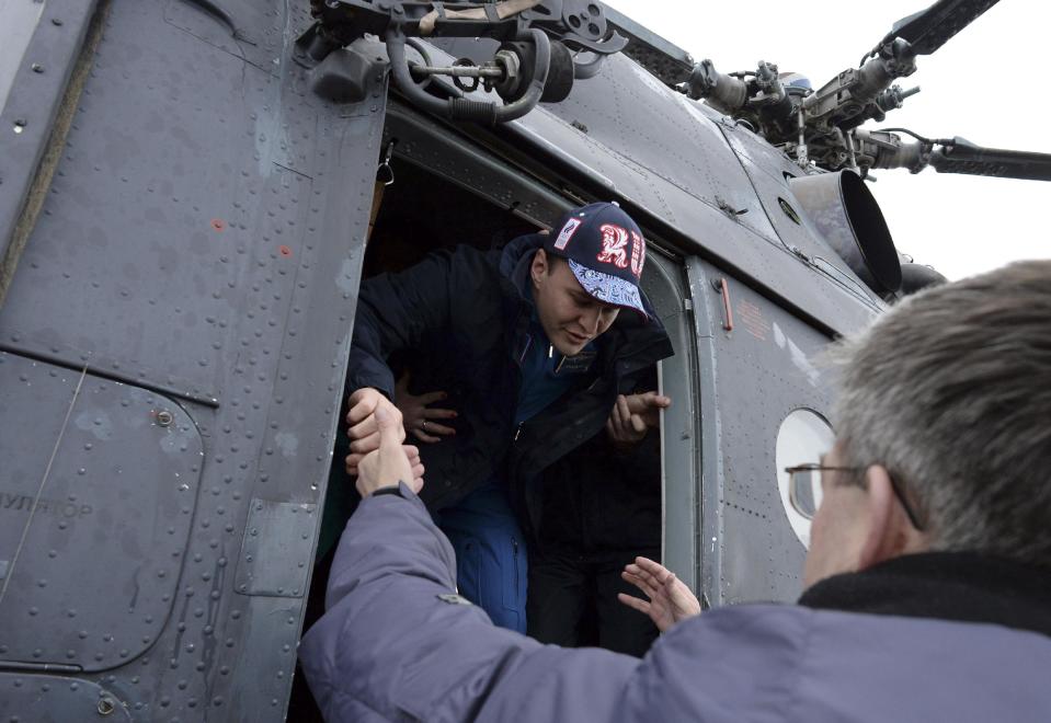 Russia's space agency ground personnel help Russian cosmonaut Sergey Ryazansky to get off a helicopter which brought the ISS crew to Karaganda, Kazakhstan, Tuesday, March 11, 2014, after the landing of Soyuz TMA-10M capsule. (AP Photo/Vasily Maximov, Pool)