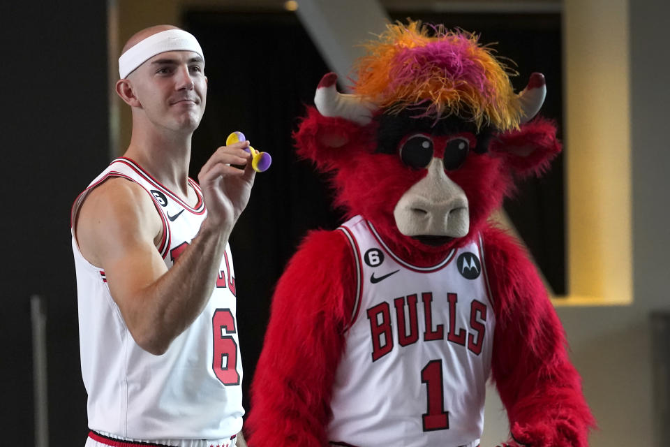 Chicago Bulls' Alex Caruso plays pop darts with Benny The Bull during the NBA basketball team's Media Day, Monday, Sept. 26, 2022, in Chicago. (AP Photo/Charles Rex Arbogast)