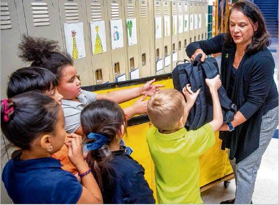 6/28/2019: Photo provided/MATT CASHOREPacqui Kelly hands out backpacks in February as Notre Dame, Kelly Cares and Cultivate Culinary partner to provide 100 kids from Madison STEAM Academy with insulated backpacks of food for the weekends.