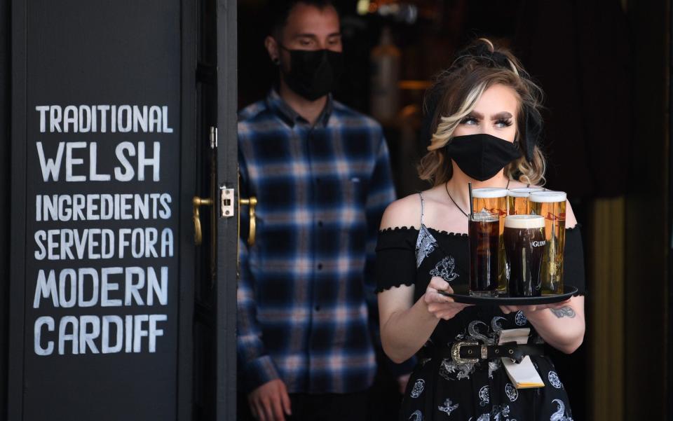 A woman carries a tray of beer at Pitch bar on April 26, 2021 in Cardiff, Wales - Matthew Horwood/Getty Images Europe