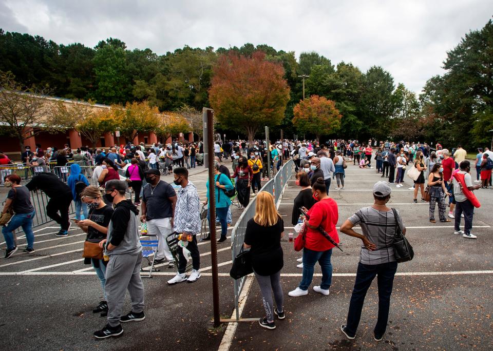 Hundreds of people wait in line for early voting on Monday, Oct. 12, 2020, in Marietta, Georgia. Eager voters have waited six hours or more in the former Republican stronghold of Cobb County, and lines have wrapped around buildings in solidly Democratic DeKalb County. (AP Photo/Ron Harris) ORG XMIT: GARH101