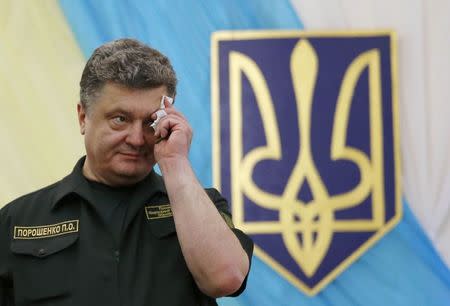 Ukrainian President Petro Poroshenko wipes his brow during a visit to the Ilich Iron and Steel Works in the southern coastal town of Mariupol September 8, 2014. REUTERS/Vasily Fedosenko