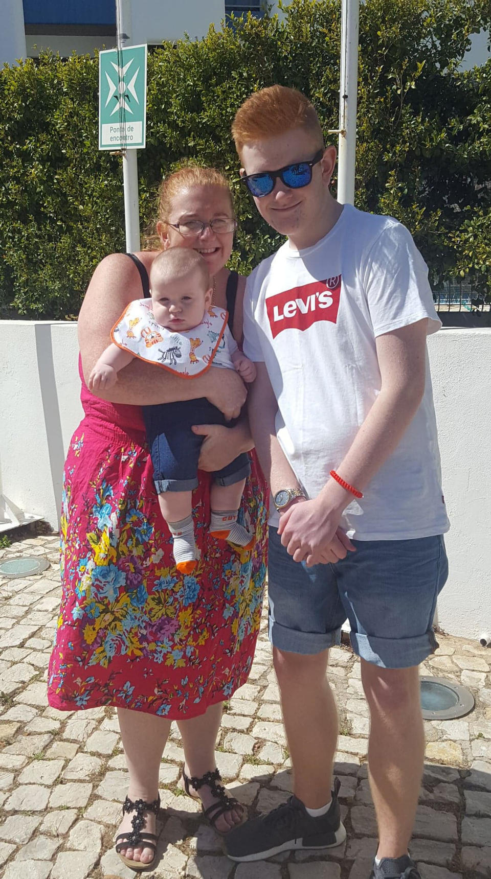 Rachel Duffy, 40, with her sons Nathan, 14, and Noah, seven months, on holiday in Portugal. [Photo: Caters]