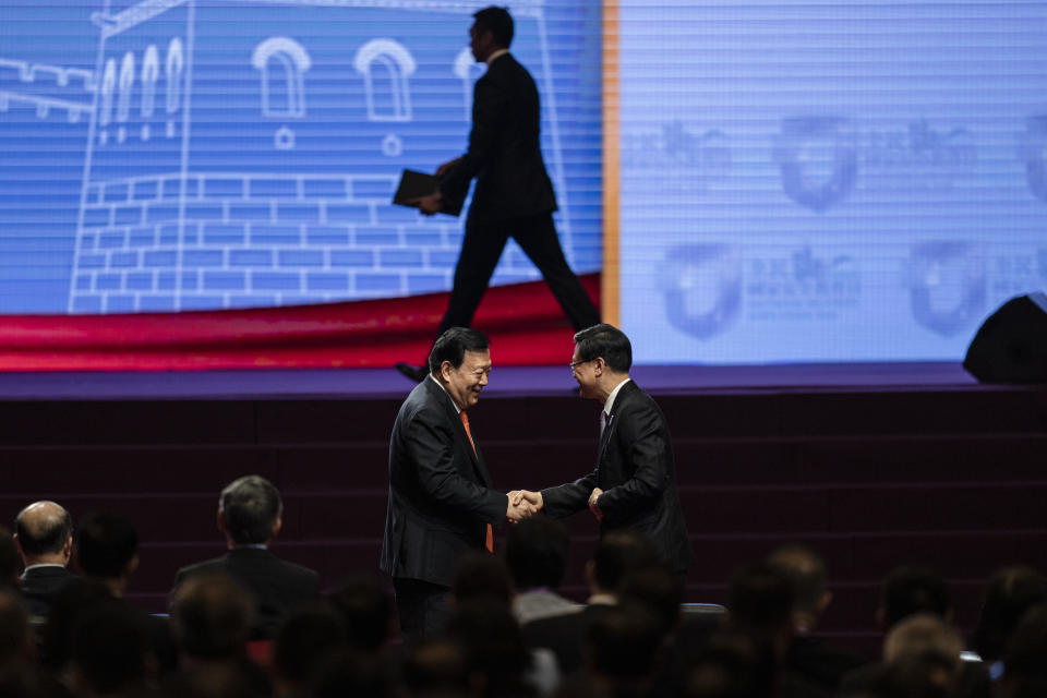 Xia Baolong, left, Director of the Hong Kong and Macau Affairs Office of the State Council, and John Lee, Chief Executive of Hong Kong, shake hands at the National Security Education Day opening ceremony in Hong Kong in Hong Kong, Saturday, April 15, 2023. China’s senior official overseeing Hong Kong’s affairs said holding demonstrations is not the only way to express people’s views weeks after the city’s strict demonstration rules sparked controversies, signaling Beijing’s vision for the financial hub.(AP Photo/Louise Delmotte)