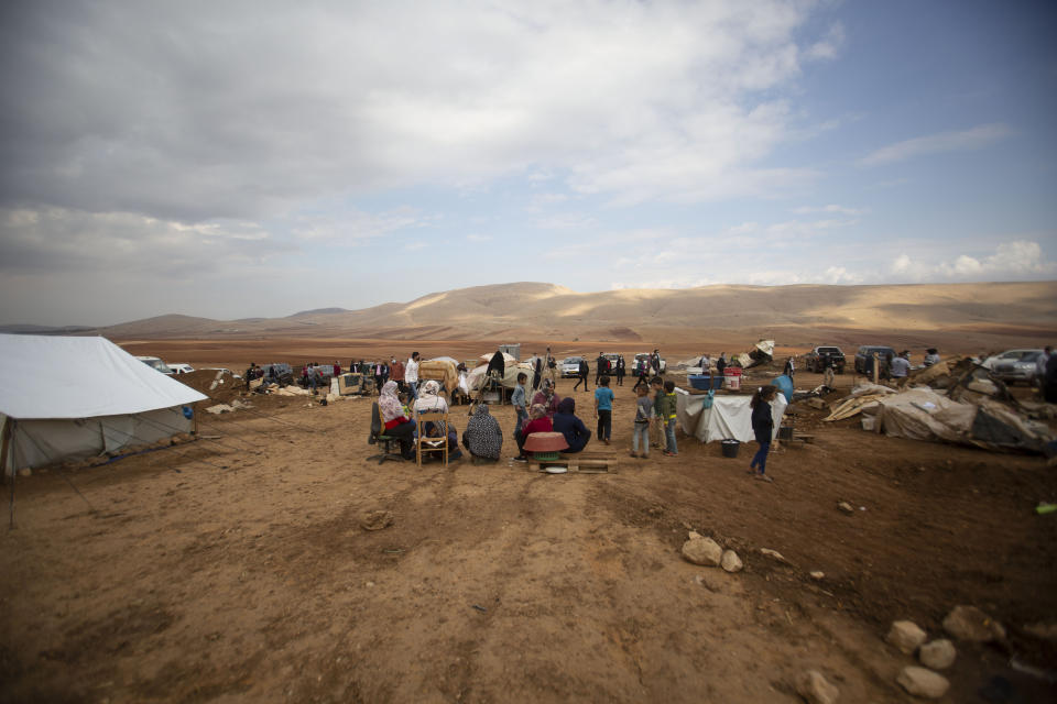 Palestinian women and children sit in Khirbet Humsu in Jordan Valley in the West Bank, Friday, Nov. 6, 2020. Israeli troops with bulldozers and heavy equipment demolished 18 tents and other structures that housed 74 people, including 41 minors, according to the Israeli rights group B'Tselem. COGAT, the Israeli military body in charge of civilian affairs in the West Bank, said an "enforcement activity" was carried out against seven tents and eight pens that were "illegally constructed" in a firing range. (AP Photo/Majdi Mohammed)