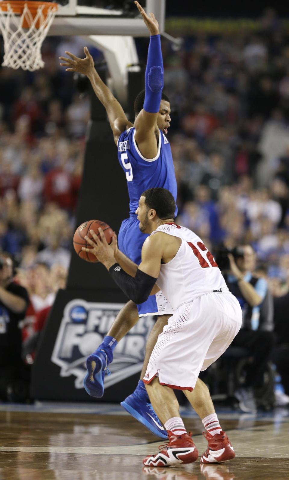 Wisconsin guard Traevon Jackson is fouled by Kentucky guard Andrew Harrison, top, while shooting a three-point basket near the end of an NCAA Final Four tournament college basketball semifinal game Saturday, April 5, 2014, in Arlington, Texas. Kentucky won 74-73. (AP Photo/Charlie Neibergall)