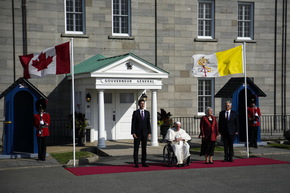 Canadian Prime Minister Justin Trudeau, left, accompanied by Governor-General Mary Simon and her husband Whit Fraser, stand for the Canadian national anthem with Pope Francis at the Citadelle de Quebec, Wednesday, July 27, 2022, in Quebec City, Quebec City, Quebec. Pope Francis is on a "penitential" six-day visit to Canada to beg forgiveness from survivors of the country's residential schools, where Catholic missionaries contributed to the "cultural genocide" of generations of Indigenous children by trying to stamp out their languages, cultures and traditions. (AP Photo/John Locher)