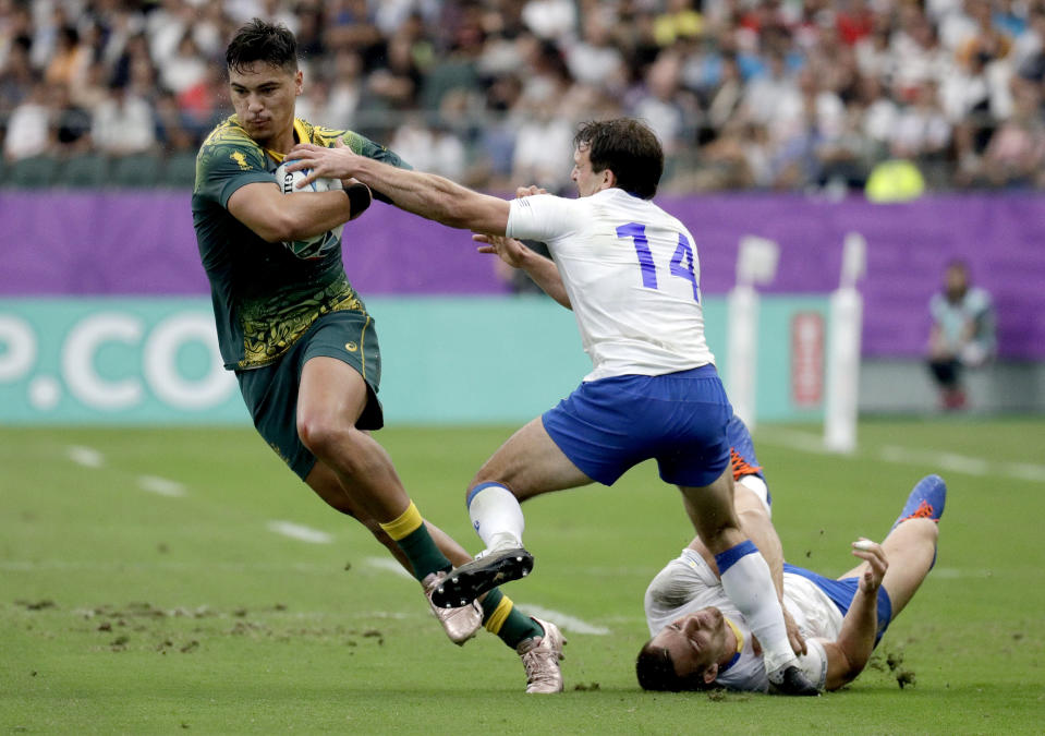 Australia's Jordan Petaia attempts to break the tackle of Uruguay's Federico Favaro during the Rugby World Cup Pool D game at Oita Stadium between Australia and Uruguay in Oita, Japan, Saturday, Oct. 5, 2019. (AP Photo/Aaron Favila)