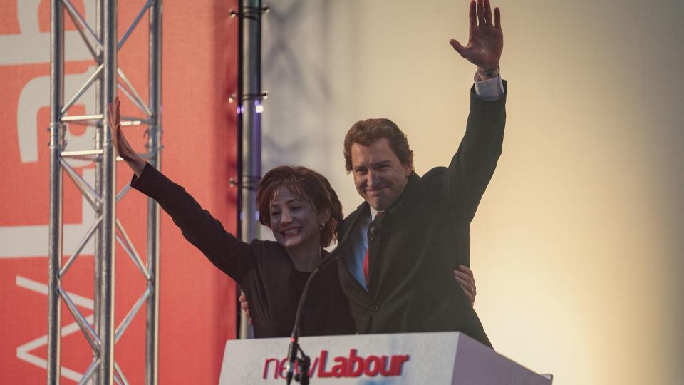 Bertie Carvel and Lydia Leonard in character wave to crowd in still from The Crown