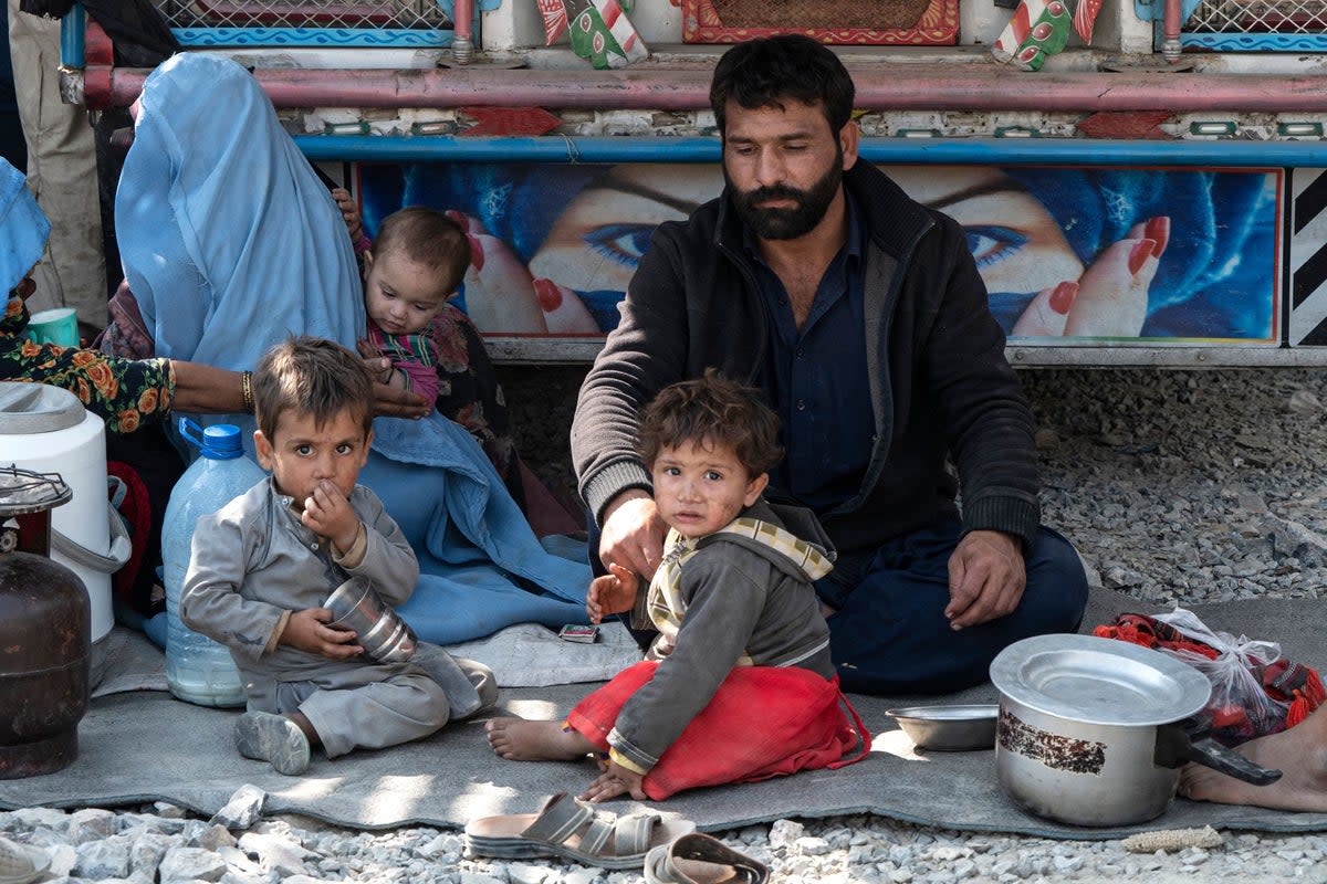 Afghan refugees receive bread from a local charity at a makeshift camp (AFP via Getty Images)