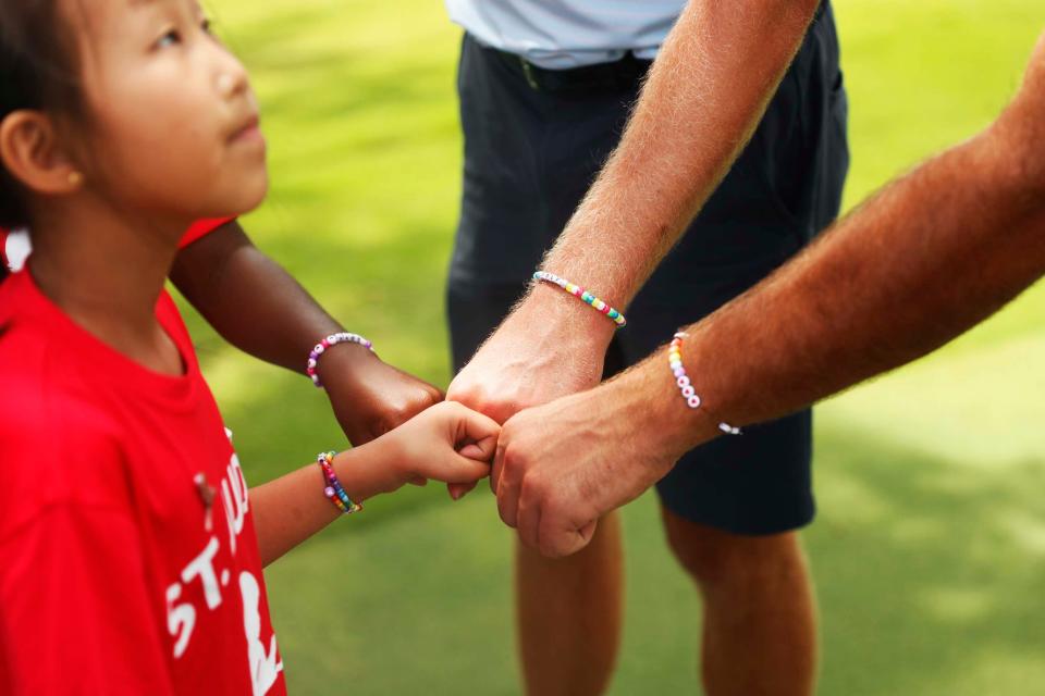 St. Jude patients Maelin-Kate, left, and Azalea take part in the TaylorMade/PING putt-around on Aug. 8, 2023, at TPC Southwind in Memphis with golfers Harris English and Taylor Montgomery. The four of them give a fist bump to show off their new friendship bracelets. The FedEx St. Jude Championship is Aug.10-13 at TPC Southwind.