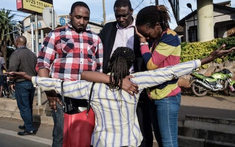 A woman is reunited with her family after her evacuation from DusitD2 compound - Credit: YASUYOSHI CHIBA/AFP/Getty Images