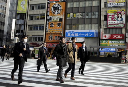 FILE PHOTO: People cross a street in a business district in Tokyo, Japan, February 16, 2016. REUTERS/Thomas Peter