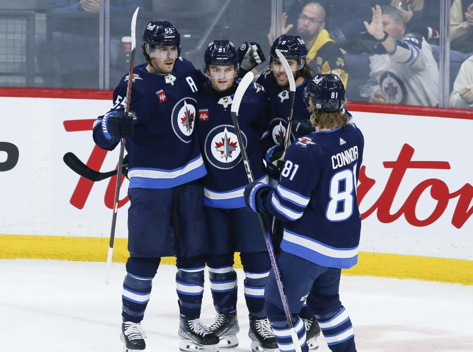 Winnipeg Jets' Mark Scheifele (55), Cole Perfetti (91), Alex Iafallo (9) and Kyle Connor (81) celebrate after Perfetti's goal against the Nashville Predators during second-period NHL hockey game action in Winnipeg, Manitoba, Thursday, Nov. 9, 2023. (John Woods/The Canadian Press via AP)