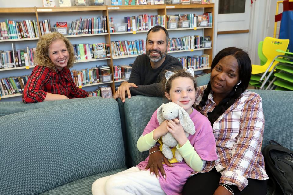 Lillie Galvin, 10 holds her stuffed animal, Bunnyella, sitting beside her nanny Cynthia Thomas, who had given her the bunny when she was a toddler, her father Andrew Galvin and mother Christie Philbrick-Wheaton at Mamaroenck Avenue School in Mamaroneck Dec. 15, 2023. Lillie and Bunnyella were reunited after the backpack Bunnyella was inside was lost during a summer vacation in Michigan. A couple found the backpack and mailed it to the school based on a receipt found in a book.