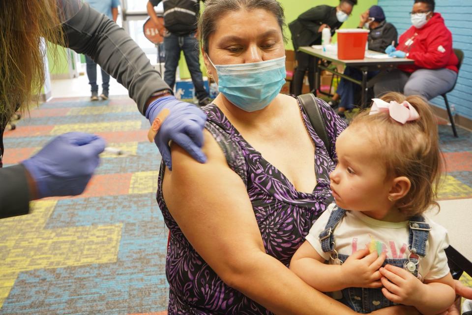 A healthcare vaccinates a woman with the Covid-19 vaccine on April 30, 2021,as the Pasadena Public Library hosts a mobile vaccine clinic set up by the Harris County Public Health, in Pasadena, Texas. / Credit: CECILE CLOCHERET/AFP via Getty Images