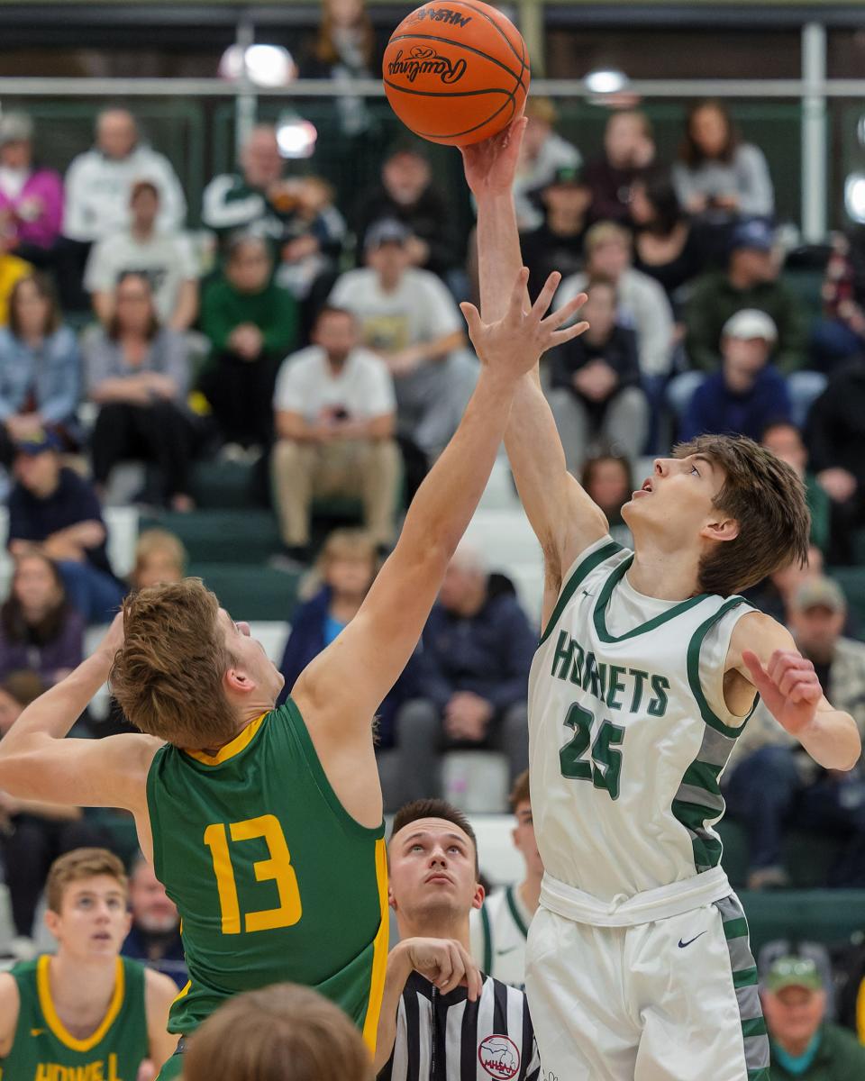 Howell's Curtis Dell (13) and Williamston's Hudson Hunt (25) tip off the 2022-23 basketball season on Tuesday, Dec. 6, 2022 in Williamston.