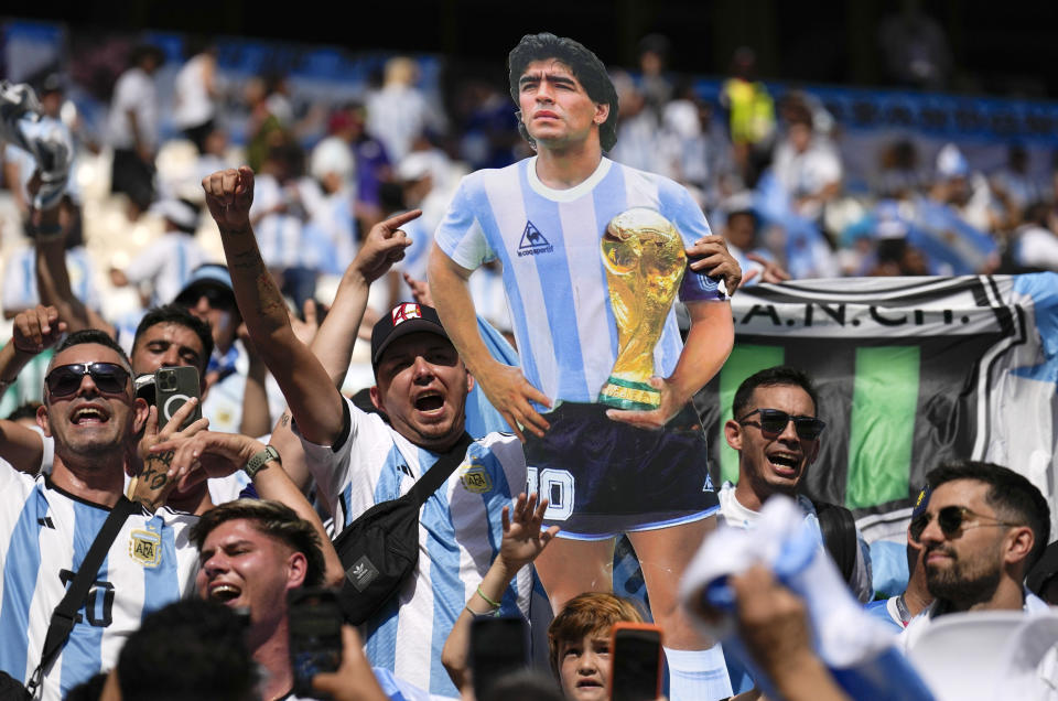Argentina's fans hold a picture of soccer legend Diego Maradona prior the World Cup group C soccer match between Argentina and Saudi Arabia at the Lusail Stadium in Lusail, Qatar, Tuesday, Nov. 22, 2022. (AP Photo/Natacha Pisarenko)