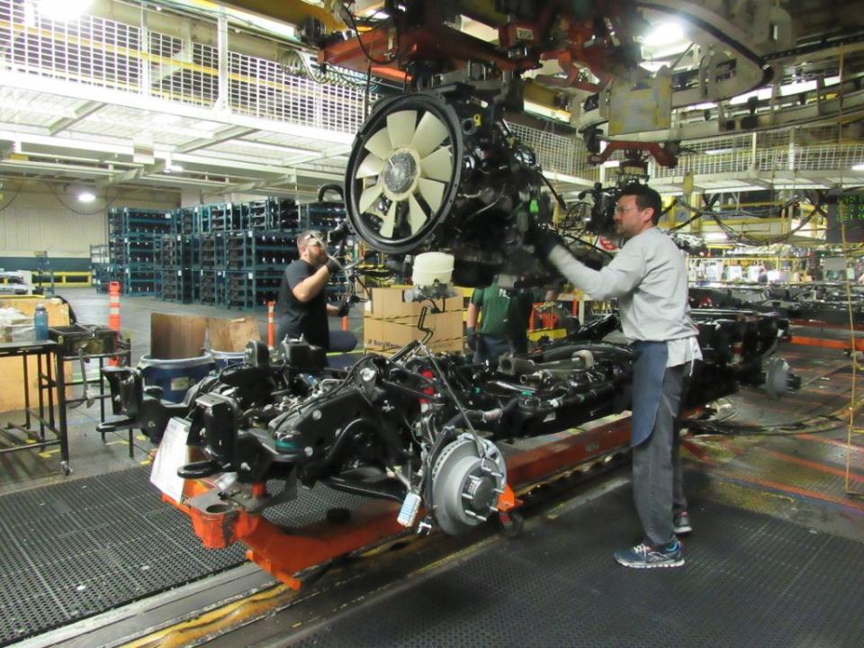 66l duramax diesel engine being placed in chassis at engine set for gm’s heavy duty pickups general motors flint assemblyuaw local 598 in flint, michigan photo general motors