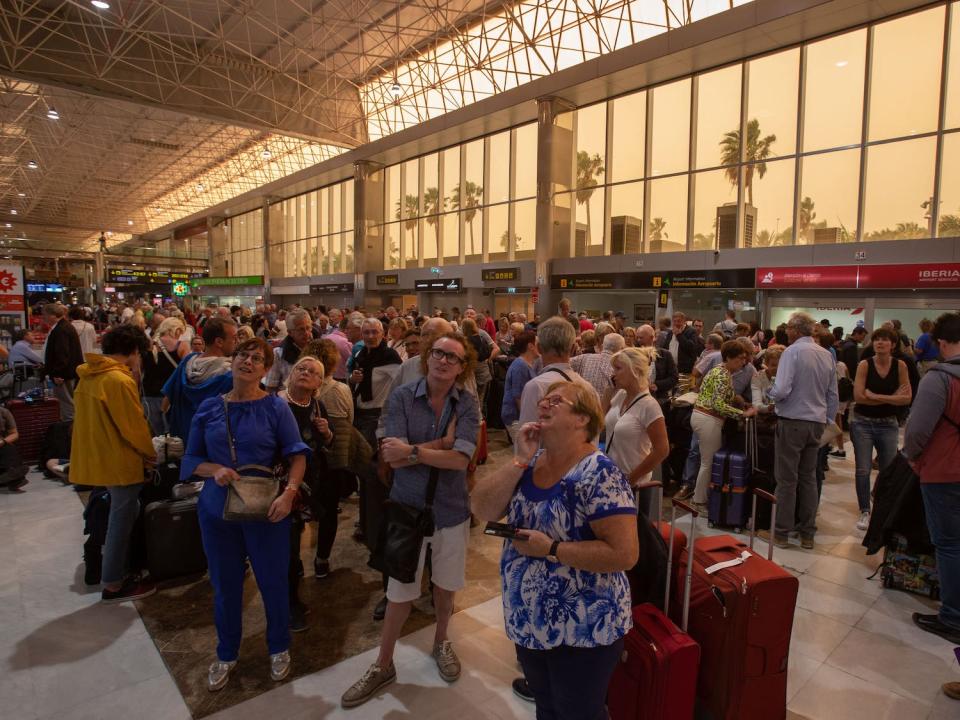 Passengers wait at Tenerife SouthReina Sofia Airport after flights were cancelled due to a sandstorm on February 23, 2020 on the Canary Island of Tenerife.