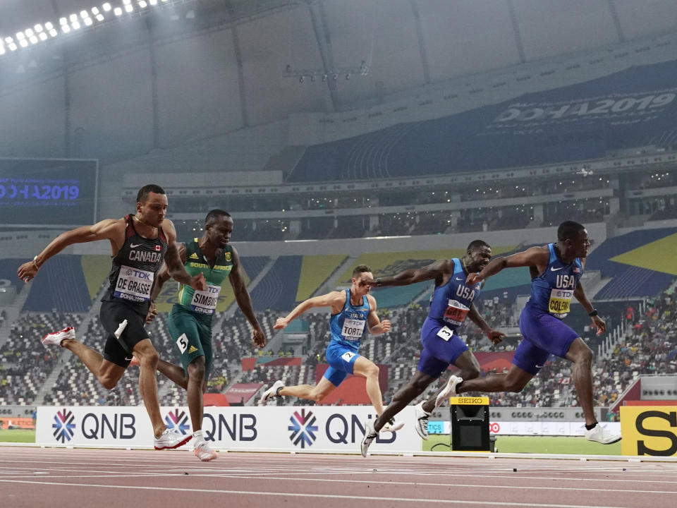 Christian Coleman, of the United States, crosses the finish line to win the men's 100 meter final ahead of silver medalist Justin Gatlin, also of the United States, during the World Athletics Championships in Doha, Qatar, Saturday, Sept. 28, 2019. Andre De Grasse, of Canada, won the bronze medal. (AP Photo/David J. Phillip)