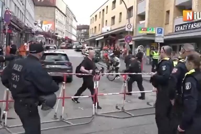 Un hombre (calvo, vestido de negro) amenazando a la policía con un pico de techos y una molotov, en Hamburgo