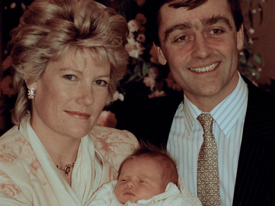 The Duke and Duchess of Westminster standing together with a baby held between them.