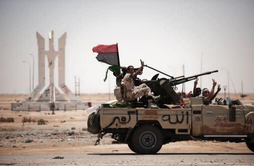 Libyan rebel fighters flash the victory sign as they drive in Ajdabiya. Turkey said it has offered Moamer Kadhafi guarantees to leave Libya but has yet to receive a reply, as rebels on Saturday accused his forces of shelling a UNESCO world heritage site