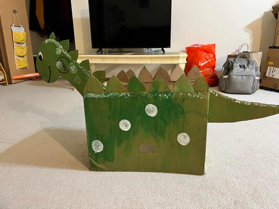 West De Pere's Rupali Kadam made a dinosaur costume for her young child out of a cardboard box.