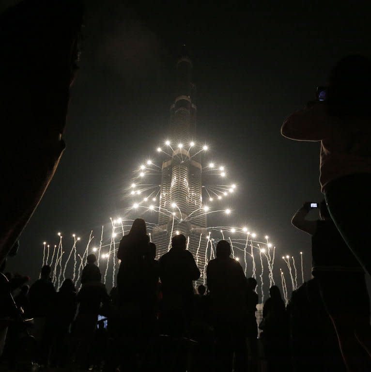 Revelers watch fireworks over Burj Khalifa in Dubai on January 1, 2013. Thousands of people gathered to celebrate the New Year at midnight