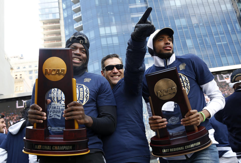 FILE - In this April 5, 2018, file photo, Villanova forward Eric Paschall, left, head coach Jay Wright, center, and guard Mikal Bridges acknowledge fans during a rally following a parade celebrating the team's NCAA college basketball championship in Philadelphia. Wright is starting his 19th season at Villanova, where he is already the winningest coach in program history.(AP Photo/Patrick Semansky, File)