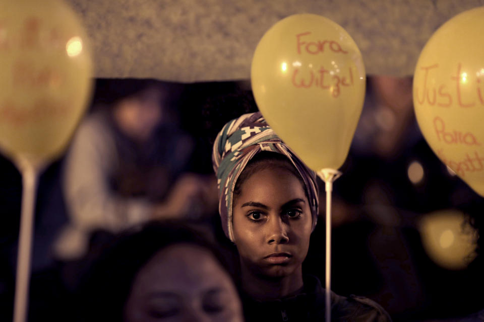 FILE - In this Sept. 23, 2019 file photo, a woman holds a balloon in memory of eight-year-old Agatha Sales Felix, who was killed by a stray bullet, during a protest against the security policy of the state, in Rio de Janeiro, Brazil. Brazilian authorities say a police officer is behind the death of the eight-year-old girl, the sixth child to die from a stray bullet in Rio de Janeiro state this year. Police presented on Tuesday, Nov. 19, 2019, the result of their investigation into the killing of Agatha, who was shot in the back on Sept. 20 in the Complexo do Alemao slum. (AP Photo/Silvia Izquierdo, File)