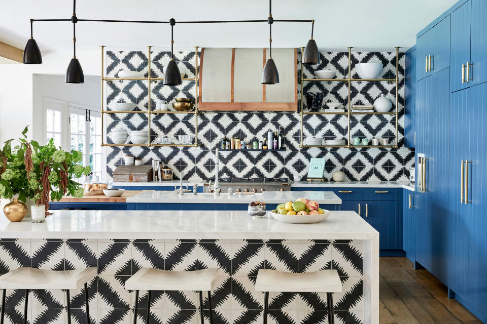 The kitchen features funky black-and-white tiles and a bold pop of blue.  (Jenna Peffley / Architectural Digest)