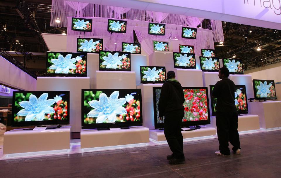 Workers look at a display of televisions by Samsung at the Las Vegas Convention Center as preparations continue for the opening of the 2007 International Consumer Electronics Show January 5, 2007 in Las Vegas, Nevada.