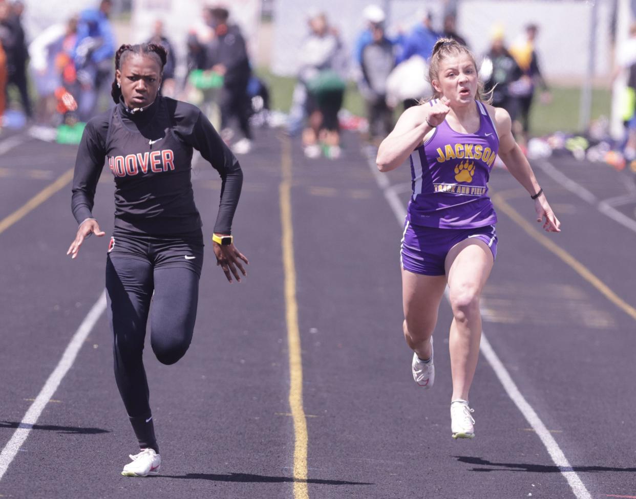 Hoover's Amahrie Harsh (left) beats out Jackson's Emily Adams at the finish line in the girls 100-meter dash at Saturday's Stark County Track and Field Championships.