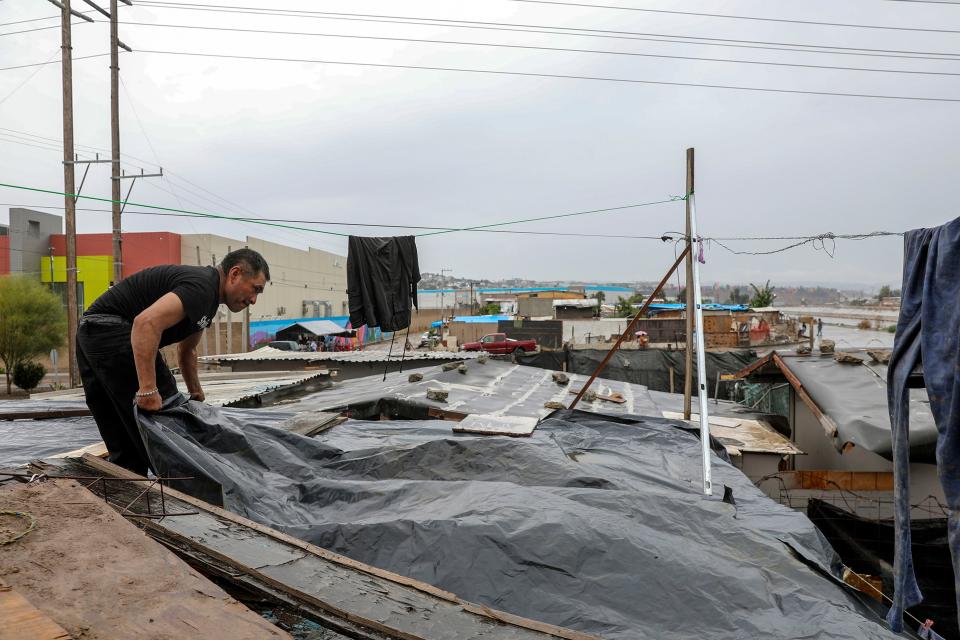 Tijuana, Baja California - August 20: Miguel Ramirez lays a tarp over a home in preparation for Tropical Storm Hilary at Colonia Nueva Esperanza Sunday, Aug. 20, 2023 in Tijuana, Baja, California. (Ana Ramirez/The San Diego Union-Tribune via AP)