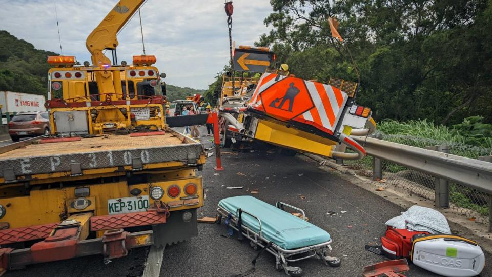 國道3號北上140.7公里通霄路段19日發生聯結貨櫃車疑似未注意車前路況，衝撞工程緩撞車事故，2名工人因閃避不及，受困車底。（中央社／民眾提供）