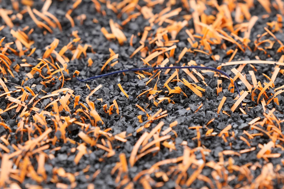 Soft plastic blades of ‘grass’ and rubber pellets, part of the make up of artificial turf at Illinois' Memorial Stadium, at an NCAA college football game between Illinois and Penn State in Champaign, Ill., Sept. 16, 2023. (AP Photo/Charles Rex Arbogast)