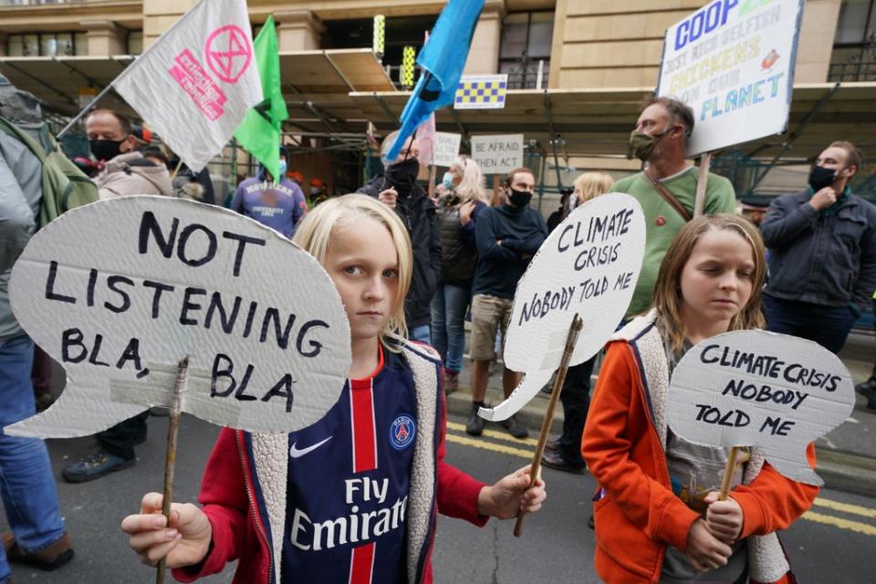 Climate activists take part in a ‘Trillion Dollar Bash’ outside the offices of JP Morgan on Waterloo Street, Glasgow, calling out the bank’s continued profits from and investment into fossil fuel projects and contribution to the suffering caused by the climate crisis (Owen Humphreys/PA) (PA Wire)